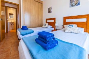 two beds in a room with blue towels on them at Casa Mika Oliastur 25 El Cotillo in El Cotillo +23 photos