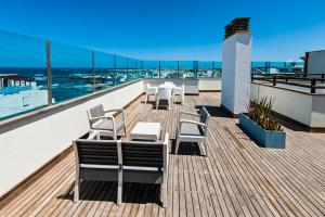 a balcony with tables and chairs on a roof at Casa Mika Oliastur 25 El Cotillo in El Cotillo
