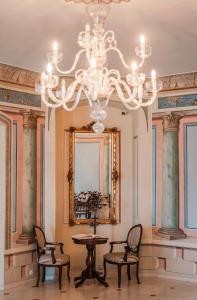 a dining room with a chandelier and a table and chairs at Dwór Kombornia Hotel&SPA in Kombornia +94 photos
