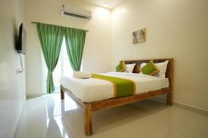 a bedroom with a bed and a window at Green Resort Pondicherry in Pondicherry +54 photos