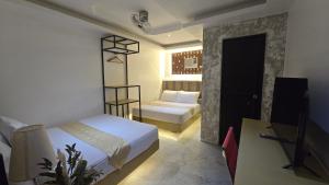 a bedroom with a bed and a desk with a television at YOLINDA's TOURIST INN in El Nido +113 photos