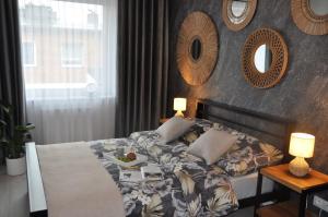 a bedroom with a bed and two mirrors on the wall at Apartament SANOVA 55 in Sanok