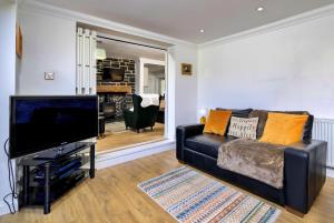 a living room with a couch and a flat screen tv at Finest Retreats - Dyffryn in Betws-y-coed