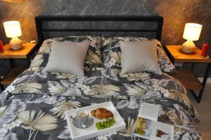 a bed with a tray with a plate of food on it at Apartament SANOVA 55 in Sanok