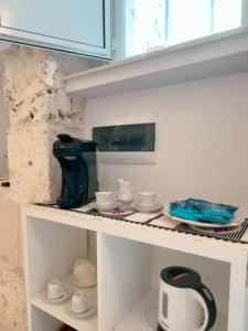 a kitchen counter with cups and saucers on it at Suite Ninfea romantic suite Ostuni center in Ostuni
