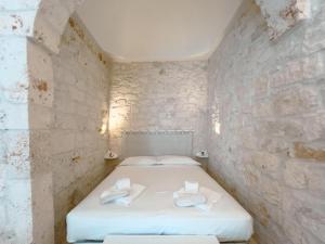 a bedroom with a bed in a stone wall at Suite Ninfea romantic suite Ostuni center in Ostuni +9 photos