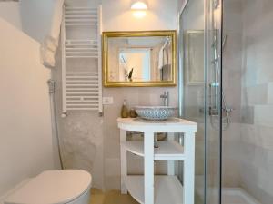 a bathroom with a sink and a toilet and a mirror at Suite Ninfea romantic suite Ostuni center in Ostuni