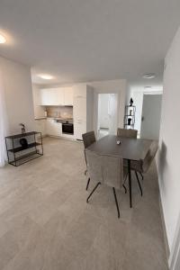 a living room with a table and chairs and a kitchen at Apartments Nilada in Zirl