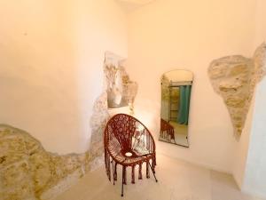 a wicker chair in a room with a mirror at Suite Ninfea romantic suite Ostuni center in Ostuni