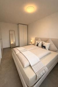 a bedroom with a large bed with white sheets and pillows at Apartments Nilada in Zirl +23 photos