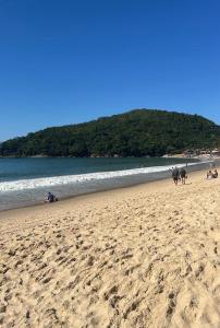 a group of people walking on the beach at Flats na praia de Trindade Paraty flats nazar in Paraty