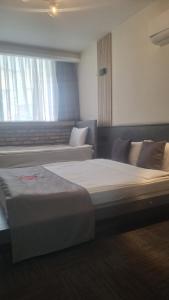 a bedroom with two beds and a window at Hotel ABBARA in İzmir