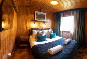 a bedroom with a bed with blue and white pillows at Kingswood Pods and Lodges in Fort William