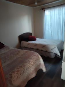 a bedroom with two beds and a window at Casa concon mascotas estacionamiento in Valparaíso