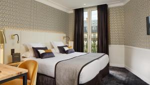 a hotel room with a large bed and a table at Hôtel le Royal Rive Gauche in Paris