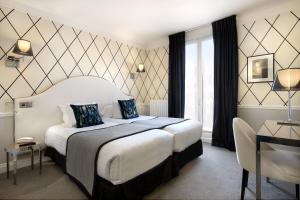 a hotel room with a large bed and a window at Hôtel le Royal Rive Gauche in Paris