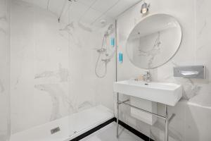 a white bathroom with a sink and a mirror at Hôtel le Royal Rive Gauche in Paris +29 photos
