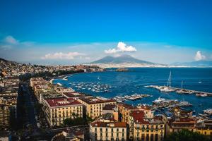 a city with a harbor with boats in the water at Angioino Central in Naples