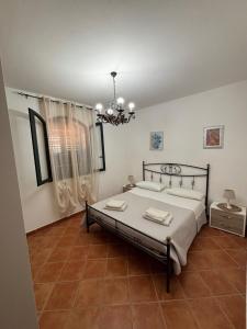 a bedroom with a bed and a chandelier at Villa Oasi Dei Sogni in Lampedusa