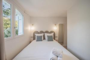 a bedroom with a large white bed with two pillows at 6P apartment in a Citadelle with POOL - Saint-Tropez in Saint-Tropez