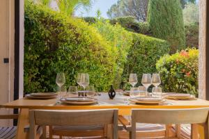 a wooden table with wine glasses on a patio at 6P apartment in a Citadelle with POOL - Saint-Tropez in Saint-Tropez