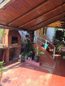 an outdoor patio with a brick fireplace with plants at Silvia Apart Confort in Puerto Iguazú