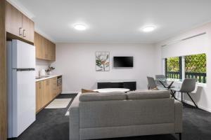 a kitchen and living room with a couch and a table at Elizabethan Lodge in Melbourne
