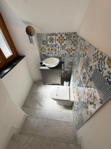 a bathroom with a sink and a toilet and tiles at Anema e Core Salerno rooms in Salerno +12 photos