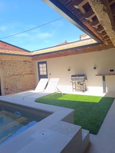 a patio with a pool and a table and grass at Retiro do Lavrador in Alvaiázere