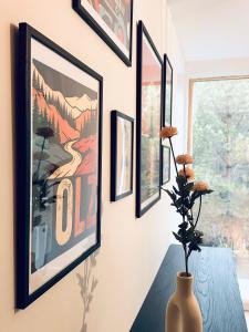 a room with pictures on the wall and a vase on a table at Silarozes in Mālpils
