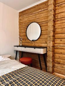 a bedroom with a mirror on a wooden wall at Silarozes in Mālpils