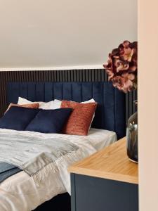 a bedroom with a bed with a blue headboard and pillows at Silarozes in Mālpils +32 photos
