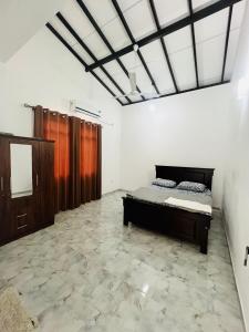a bedroom with a bed in the middle of a room at White House in Ranala