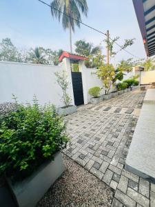 a brick walkway with a white wall and a door at White House in Ranala