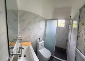 a bathroom with a shower and a toilet and a sink at White House in Ranala