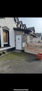 a house with a white door and a fence at Station apartment in Llanberis +1 photo