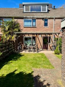 a brick house with a patio with a picnic table at Nijmegen Cozy Guest Rooms in Nijmegen +21 photos