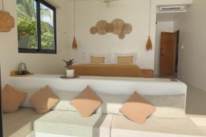 a bedroom with a bed and a couch with pillows at Trogon's Perch in San Isidro +37 photos