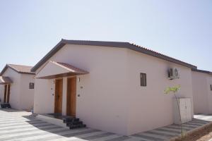 a white building with a porch at Palm Glow Resort in Daisara