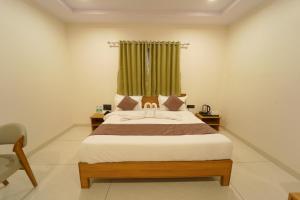 a bedroom with a bed with a green curtain at Palm Glow Resort in Daisara