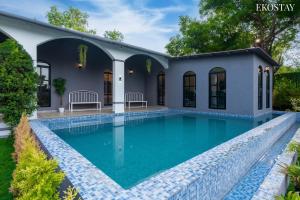 a swimming pool in the backyard of a house at EKOSTAY Luxe - Casa Roma in Alibaug