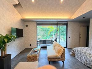 a living room with a couch and a table at 奄美 Palm Tree Terrace in Ōkachi