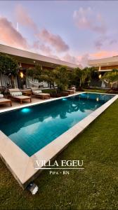 a large swimming pool in front of a building at Villa Egeu Praia da Pipa in Pipa