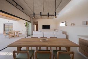 a dining room and living room with a wooden table and chairs at Casa Victoria El Roque in Roque