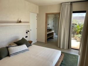 a bedroom with a bed and a view of a bathroom at Casa Victoria El Roque in Roque +16 photos