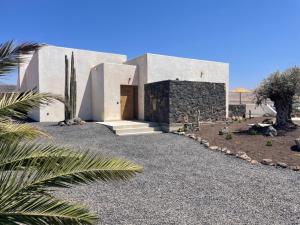 a house in the desert with a gravel driveway at Casa Victoria El Roque in Roque