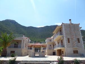 a large building with a palm tree in front of a mountain at Karantonis House in Leonidion