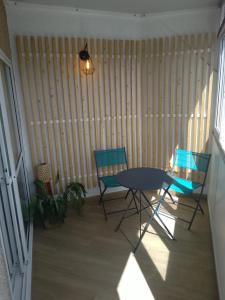 a dining room with two chairs and a table at Ático en la Playa de Cangas in Cangas de Morrazo