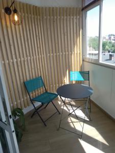two chairs and a table in a room with a window at Ático en la Playa de Cangas in Cangas de Morrazo
