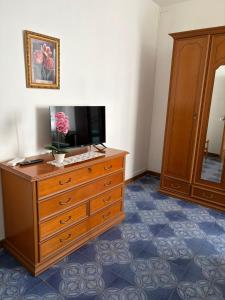 ein Zimmer mit einer Kommode, auf der ein Fernseher steht in der Unterkunft U' Cerrito in Orria